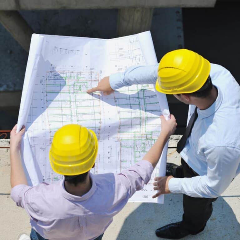 Swimming pool engineers reviewing blueprints for a new pool construction project