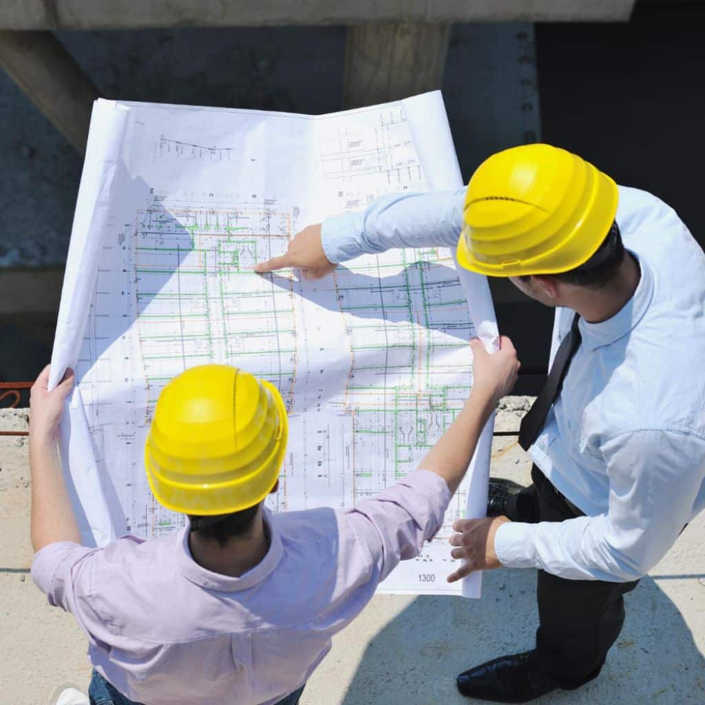 Swimming pool engineers reviewing blueprints for a new pool construction project